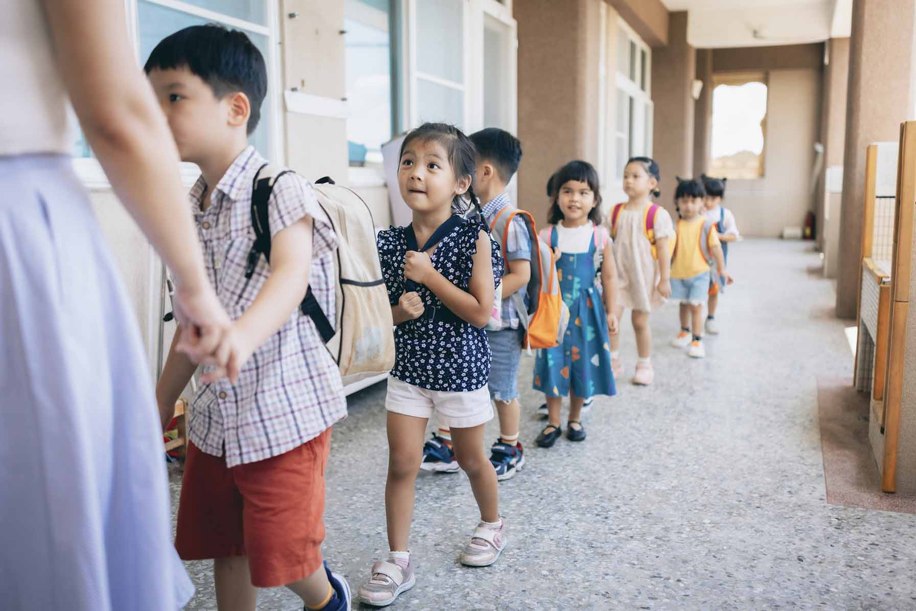A little girl looks excited and nervous as she lines up with class mates.